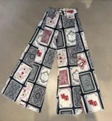 Pantalón jean wide leg con estampado de cartas de póker y dados.