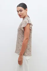 Blusa estampada con cuello mao y mangas cortas con volados.