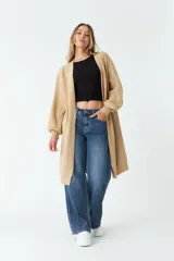 Saco tejido color beige, largo hasta la rodilla, con mangas largas abullonadas y bolsillos laterales.