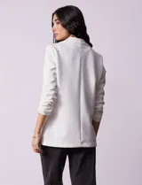Blazer blanco de Robert Louis con cuello con solapa, abertura central con botón, bolsillos delanteros y mangas 3/4 con frunces.