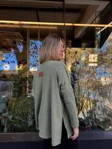 Remerón verde militar de tejido de punto con mangas largas y aberturas laterales.