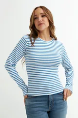 Remera de manga larga ajustada al cuerpo, con cuello redondo y tejido acanalado, a rayas horizontales blancas y azules.