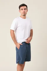 Bermuda deportiva de nylon color verde oliva, de corte suelto, con cintura elástica y cordón de ajuste. Cuenta con detalles de líneas verticales en los costados y bolsillos laterales con cierre.