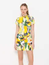 Vestido corto de lycra estampada con limones, cuello media polera y cierre metálico en la espalda.