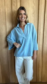 Blusón celeste de mangas 3/4 con cuello polo y escote en V.