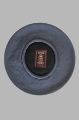 Boina gris de hilo con etiqueta negra y roja de la marca Tolosa Tupida en el interior.