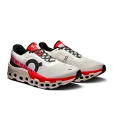 Championes de running On Cloudmonster 2, color blanco con detalles en negro, rojo y rosa.