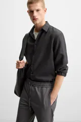 Pantalón color arena de corte recto, confeccionado en tejido elástico. Cuenta con cintura elástica ajustable con cordón, bolsillos laterales y bolsillos de vivo en la parte trasera.