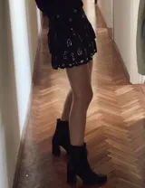 Botín de cuero color marrón con caña media, punta fina y taco geométrico de 10 cm.