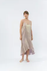 Vestido midi color lila metálico de breteles finos regulables, escote en V y ruedo asimétrico con leve vuelo.