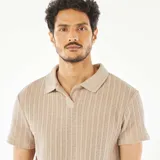Remera polo de manga corta color beige, de punto gofrado con textura acanalada vertical.