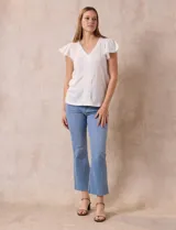 Blusa blanca de tejido pointelle con escote en V y aplique de puntilla en el cuello y mangas cortas con volados.