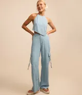 Top celeste de jeans con frente única, lazo en la espalda y detalle de caracolas en las puntas.