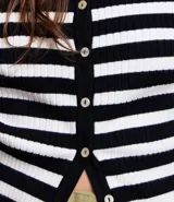 Cardigan de punto con cuello redondo, mangas largas, abotonado delantero y estampado de rayas horizontales en blanco y negro.