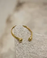 Brazalete rígido abierto de bronce con forma de herradura.