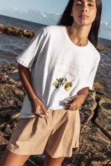 Remera blanca de algodón con estampado de un limón y la frase "Limoncello per favore" en letras doradas.