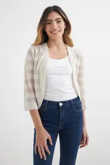 Cardigan corto de tejido de punto liviano, color crudo o beige muy claro, con diseño de rayas horizontales transparentes. Tiene mangas tres cuartos y escote abierto.