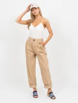 Pantalón de vestir color beige, tiro alto, con pinzas delanteras y pierna ancha.