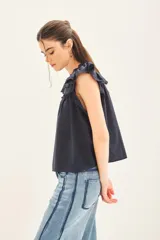 Camisa blanca de algodón con escote redondo, mangas cortas con volados y detalles de puntilla en el canesú.