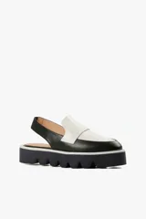 Mocasín slingback de cuero negro con detalle blanco en el empeine y base con plataforma dentada.
