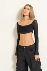 Blusa crop top negra de mangas largas con transparencias y escote drapeado.