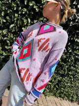 Sweater de hilo tejido a mano con diseño de intarsia y bordados coloridos, hecho de manera artesanal.