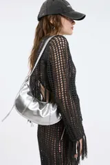 Cartera de hombro plateada con correa fina al tono.