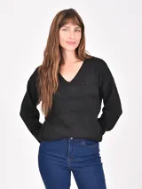 Buzo de tejido de punto negro, con cuello en V y mangas largas. Presenta franjas horizontales con pequeños calados decorativos.