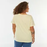 Remera color amarillo pálido de corte recto, con cuello redondo y manga corta. Presenta un detalle de abertura en el hombro izquierdo con efecto retorcido.