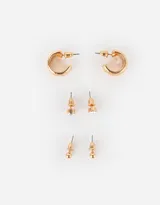 Set de tres pares de aros dorados: un par de argollas gruesas, un par de aros con strass y un par de aros con bolitas.