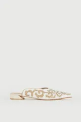 Zueco de cuero beige con detalles bordados en plateado dorado, diseño elegante y cómodo.