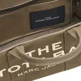 Tote bag de lona color beige con la inscripción "THE TOTE BAG MARC JACOBS" en el frente. Incluye cierre de cremallera, asas superiores y una correa de hombro ajustable y extraíble de color negro.