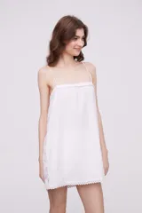 Vestido corto blanco con breteles finos y detalle de puntilla en el escote, laterales y ruedo.