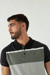 Remera tipo polo de manga corta con diseño a bloques de color: negro en cuello y mangas, gris oscuro en la parte superior del pecho, blanco en el centro y gris claro en el resto del cuerpo.