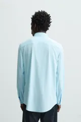 Camisa negra de manga larga con cuello italiano abierto y cierre frontal de botonadura. Corte slim fit.