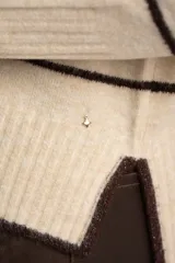 Sweater color crema con rayas horizontales en tonos marrón, bordeaux y beige.