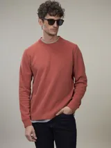 Buzo de frisa color gris topo, de corte clásico y cuello redondo.