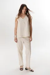 Top sin mangas confeccionado en mezcla de lino y algodón color marrón, con escote en V y pespuntes blancos decorativos en contraste.