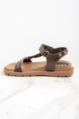 Sandalias marrones de cuero con suela gruesa y tachas doradas en forma de estrella y circulares.