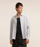 Camisa celeste de viscosa y poliéster con textura arrugada, cuello tradicional, manga larga y abotonadura frontal completa.