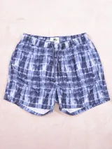 Short de baño con estampado a cuadros en tonos azules y blancos, con cintura elástica y cordón ajustable.