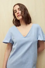 Vestido corto color beige, de corte recto y manga corta con volados.