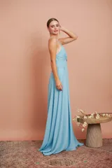 Vestido largo de fiesta celeste, con escote en V profundo y breteles finos. Presenta un detalle de frunce con aplique brillante en el centro del busto y falda acampanada.