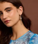 Caravana asimétrica plateada con aro, colgante de estrella con strass y piercing con spikes y strass. Cierre por tornillo.