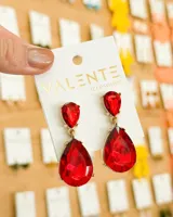 Aros colgantes con forma de lágrima, con engarce dorado y cristales rojos facetados.