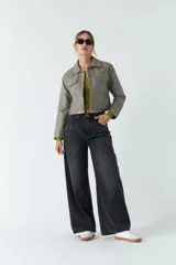 Sobrecamisa cropped de cuero sintético color negro, con cuello clásico, cierre frontal con botones, mangas largas y bolsillos frontales con solapa.