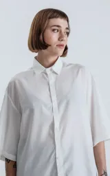 Camisa blanca de corte amplio con mangas cortas.