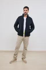 Campera capitoneada liviana color azul marino, con cuello alto y dos bolsillos exteriores con cierre. Interior del cuello a contratono.