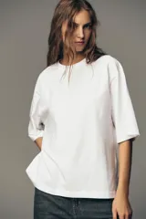 Camiseta blanca de algodón, corte boxy fit, cuello redondo, manga corta y etiqueta contrastante en la espalda.
