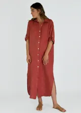 Vestido camisero largo color beige, con cuello clásico, abotonadura frontal completa, mangas 3/4 con trabilla y aberturas laterales.